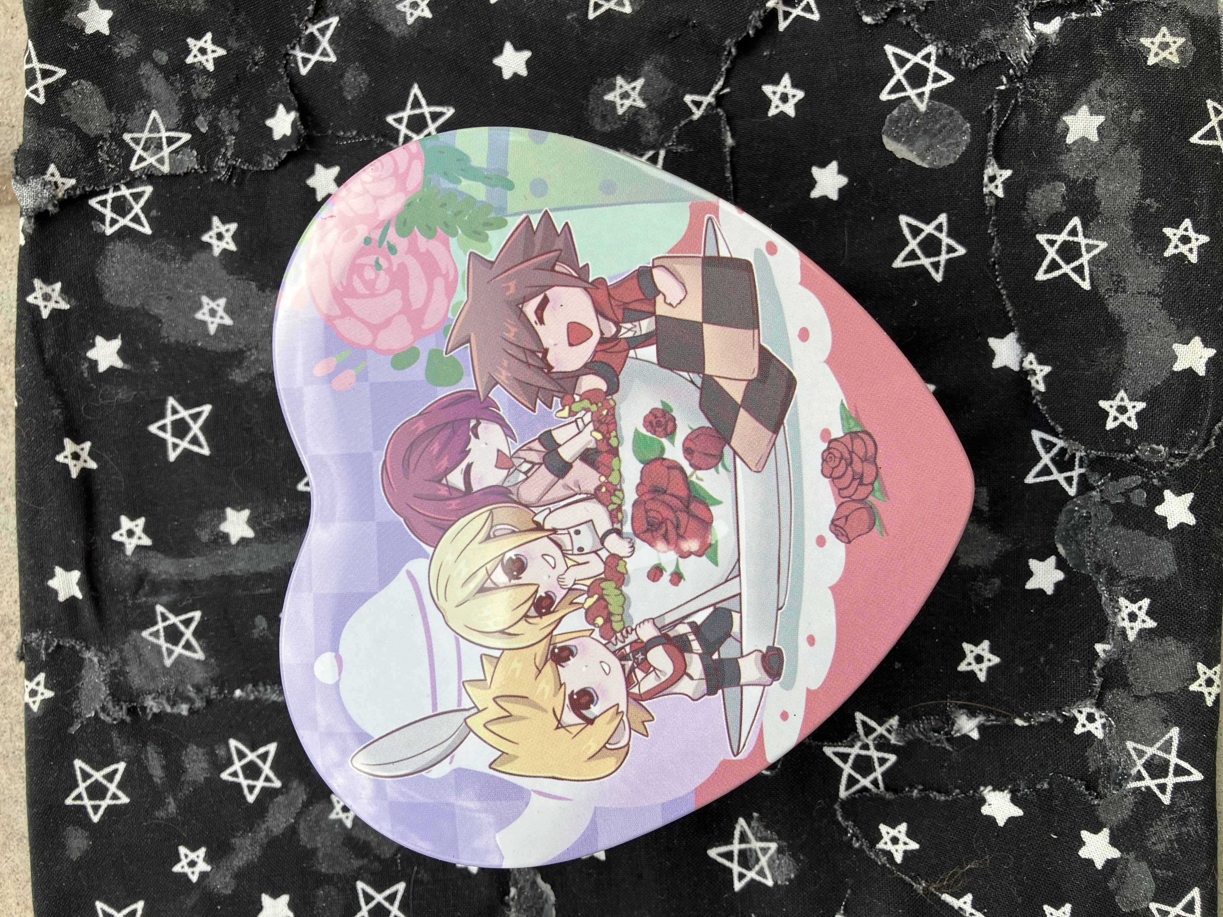 Front of trinket case with chibi Kindgom Hearts Roxas, Namine, Kairi, and Sora on plates and flower filled cups next to a tea pot and a pot of flowers.